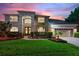 Two-story house with a three-car garage, landscaping, and a paved driveway at 13005 Islamorada Dr, Orlando, FL 32837