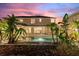 Two-story home with a pool and lush landscaping at sunset at 13005 Islamorada Dr, Orlando, FL 32837