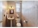 Elegant powder room with pedestal sink, decorative tile, and mirror at 13005 Islamorada Dr, Orlando, FL 32837