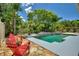 Relaxing pool area with red chairs and lush landscaping at 13005 Islamorada Dr, Orlando, FL 32837
