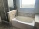 Bright bathroom featuring a tub with tile surround and a glass-enclosed shower at 14501 Grove Resort Ave # 1407, Winter Garden, FL 34787