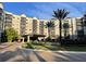 Luxury condominium exterior with covered entrance, lush landscaping, and multiple floors with private balconies at 14501 Grove Resort Ave # 1407, Winter Garden, FL 34787