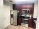 Kitchen featuring stainless steel appliances and dark wood cabinets at 14501 Grove Resort Ave # 1407, Winter Garden, FL 34787