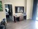 Modern living room with a TV over console table and a glimpse of an inviting bedroom at 14501 Grove Resort Ave # 1407, Winter Garden, FL 34787