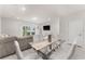 Elegant dining area with glass top table and white chairs near living room at 2033 Canny Cv, Winter Park, FL 32792