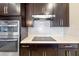 Modern kitchen with cooktop and dark wood cabinets at 2158 Stillwood Way, St Cloud, FL 34771