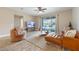 Living room with leather sectional sofa, large TV, and sliding doors leading to the pool at 2158 Stillwood Way, St Cloud, FL 34771