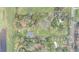 Aerial view of a property featuring verdant trees surrounding a cozy home, with a pond in the distance at 2432 4Th St, Orlando, FL 32820