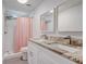 Bright bathroom featuring a double sink vanity with marble counters and a shower with a pink curtain at 2432 4Th St, Orlando, FL 32820