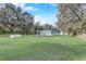 Expansive front yard with a lush green lawn and mature trees, showcasing the property's curb appeal at 2432 4Th St, Orlando, FL 32820