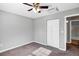 Bright bedroom features a ceiling fan, neutral walls, closet, and carpet flooring at 43 Water Track Dr, Ocala, FL 34472
