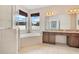 Bright bathroom with a soaking tub, glass shower, and double vanity with granite countertops at 4455 Indigo Sky Ln, Kissimmee, FL 34744