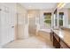 Bright bathroom with a soaking tub, glass shower, and double vanity with granite countertops at 4455 Indigo Sky Ln, Kissimmee, FL 34744