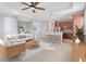 Bright, open-concept living room flows into kitchen and dining area, featuring a ceiling fan and neutral decor at 4455 Indigo Sky Ln, Kissimmee, FL 34744