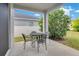 Covered outdoor patio area with a table and chairs perfect for enjoying the outdoors at 4455 Indigo Sky Ln, Kissimmee, FL 34744
