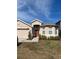 Tan one-story house with red door and landscaping at 5427 Los Palma Vista Dr, Orlando, FL 32837