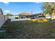 A view of the backyard with a lawn, patio with seating, screened in pool, and fenced yard at 657 Hunters Run Blvd, Lakeland, FL 33809