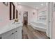 Elegant bathroom with a double vanity, a large soaking tub, and wood-style flooring at 657 Hunters Run Blvd, Lakeland, FL 33809