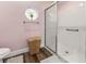 Clean bathroom with a shower, a toilet, a charming octagon window, and wood-style flooring at 657 Hunters Run Blvd, Lakeland, FL 33809