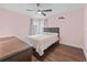 Relaxing bedroom with a ceiling fan, a large window, a dresser, and wood-style flooring at 657 Hunters Run Blvd, Lakeland, FL 33809