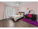 Bright bedroom with a ceiling fan, a window, dark furniture, and wood-style flooring at 657 Hunters Run Blvd, Lakeland, FL 33809