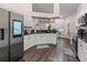 Modern kitchen featuring white cabinetry, stainless steel appliances, and dark granite countertops at 657 Hunters Run Blvd, Lakeland, FL 33809