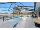 A screened-in pool features an outdoor dining area with a table, chairs, and lounge seating at 657 Hunters Run Blvd, Lakeland, FL 33809
