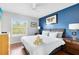 Main bedroom with king-size bed and blue accent wall at 8519 Bay Lilly Loop, Kissimmee, FL 34747