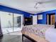 Bedroom with a queen bed, sliding doors to patio, and blue walls at 925 Wintergreen Blvd, Fern Park, FL 32730