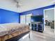 Bright bedroom with blue walls, floral bedding, and sliding glass doors at 925 Wintergreen Blvd, Fern Park, FL 32730