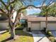 Front view of townhouse with driveway, landscaping, and mature trees at 925 Wintergreen Blvd, Fern Park, FL 32730