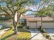 Front view of townhouse with driveway, landscaping, and mature trees at 925 Wintergreen Blvd, Fern Park, FL 32730