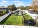 A backyard view features a pool and a trampoline on a lush lawn, enclosed by a white fence for privacy at 1101 Maidenmoor Rd, Winter Garden, FL 34787