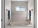 A built-in tub is surrounded by tiled walls, with a small window providing natural light at 1101 Maidenmoor Rd, Winter Garden, FL 34787
