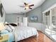 Bright bedroom with a ceiling fan, wood floor, and sliding doors to the lanai at 1101 Maidenmoor Rd, Winter Garden, FL 34787