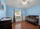 A room featuring a crib, changing table and ceiling fan at 1101 Maidenmoor Rd, Winter Garden, FL 34787
