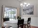 Dining room with a view of the screened pool area, with a large chandelier and neutral color scheme at 1101 Maidenmoor Rd, Winter Garden, FL 34787