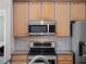 Close-up of kitchen appliances including microwave, oven, and granite countertops with tile backsplash at 1101 Maidenmoor Rd, Winter Garden, FL 34787