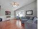Bright living room with high ceilings, hardwood floors, ceiling fan, and a comfortable gray sectional couch at 1101 Maidenmoor Rd, Winter Garden, FL 34787