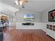 Open-concept living room with hardwood floors, wall-mounted TV, and view of the kitchen and dining area at 1101 Maidenmoor Rd, Winter Garden, FL 34787