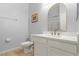 Bathroom with a toilet, vanity with quartz countertop, and a large mirror at 114 Rum Run, Davenport, FL 33837