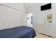 Bedroom with a queen bed, dresser, and view into laundry room at 114 Rum Run, Davenport, FL 33837