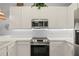 Well-lit kitchen with stainless steel appliances and white cabinetry at 114 Rum Run, Davenport, FL 33837