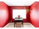 Bright bedroom with red walls and a vanity with large window at 1232 Saint James Rd, Orlando, FL 32808