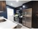 Modern kitchen with dark cabinetry, stainless steel appliances, and quartz countertops at 1232 Saint James Rd, Orlando, FL 32808