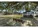 Large backyard with mature trees, a swing bench, and an outdoor shelter at 15040 Ne 248Th Avenue Rd, Fort Mc Coy, FL 32134