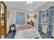 Bright bedroom featuring blue patterned curtains and natural light at 15040 Ne 248Th Avenue Rd, Fort Mc Coy, FL 32134