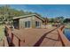 Exterior view of lake house featuring a spacious deck with an umbrella-covered dining area at 15040 Ne 248Th Avenue Rd, Fort Mc Coy, FL 32134