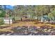 House, shed, and lake view behind wooden fence and shade trees at 15040 Ne 248Th Avenue Rd, Fort Mc Coy, FL 32134