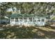 Rear exterior view of a white home with a green metal roof and multiple windows at 15040 Ne 248Th Avenue Rd, Fort Mc Coy, FL 32134